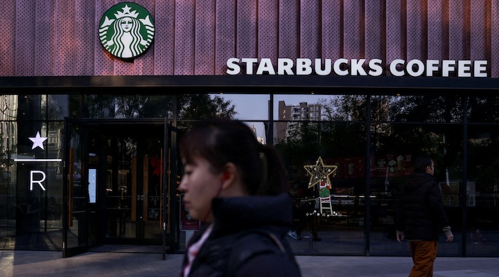 People walk past a Starbucks coffee shop in Beijing
