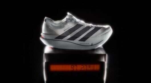 A white and black Adidas against a black background.