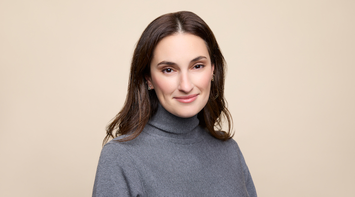 Studs CEO Anna Harman in a grey sweater against a taupe background.