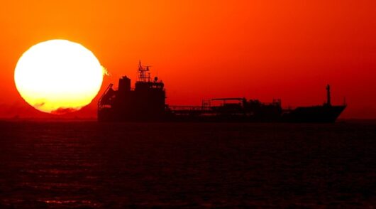 A tanker silhouetted against the setting sun.